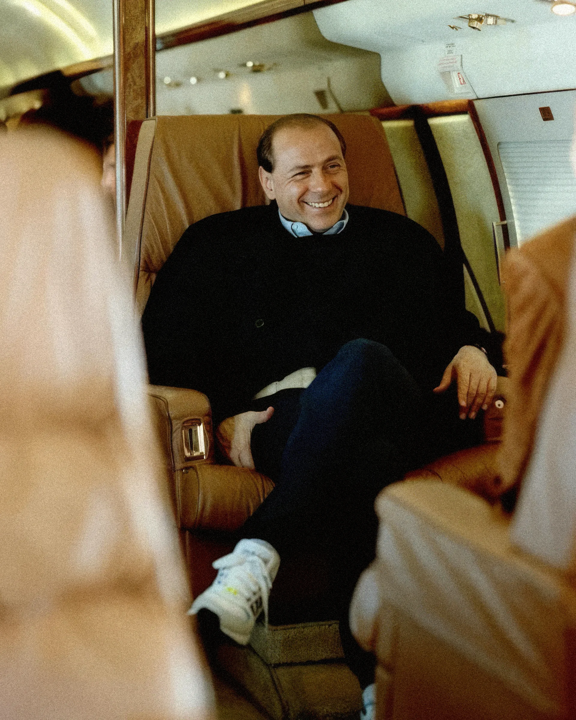 Un uomo sorridente seduto su una poltrona di pelle, in aereo.