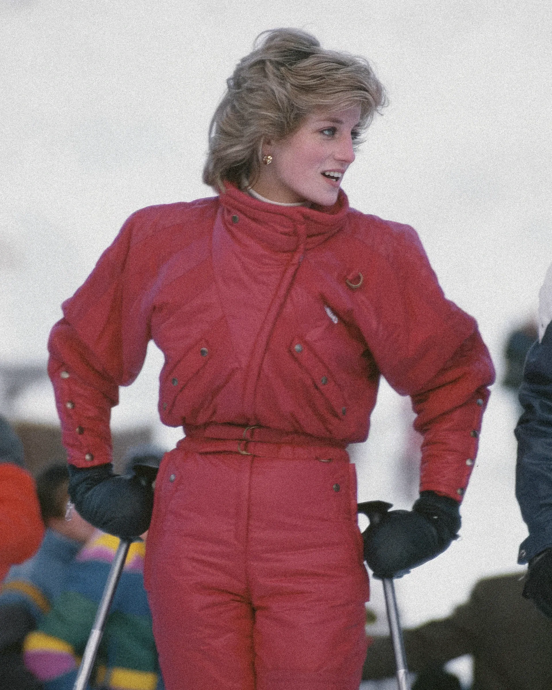 Una donna in tuta da sci rossa, sulla neve.